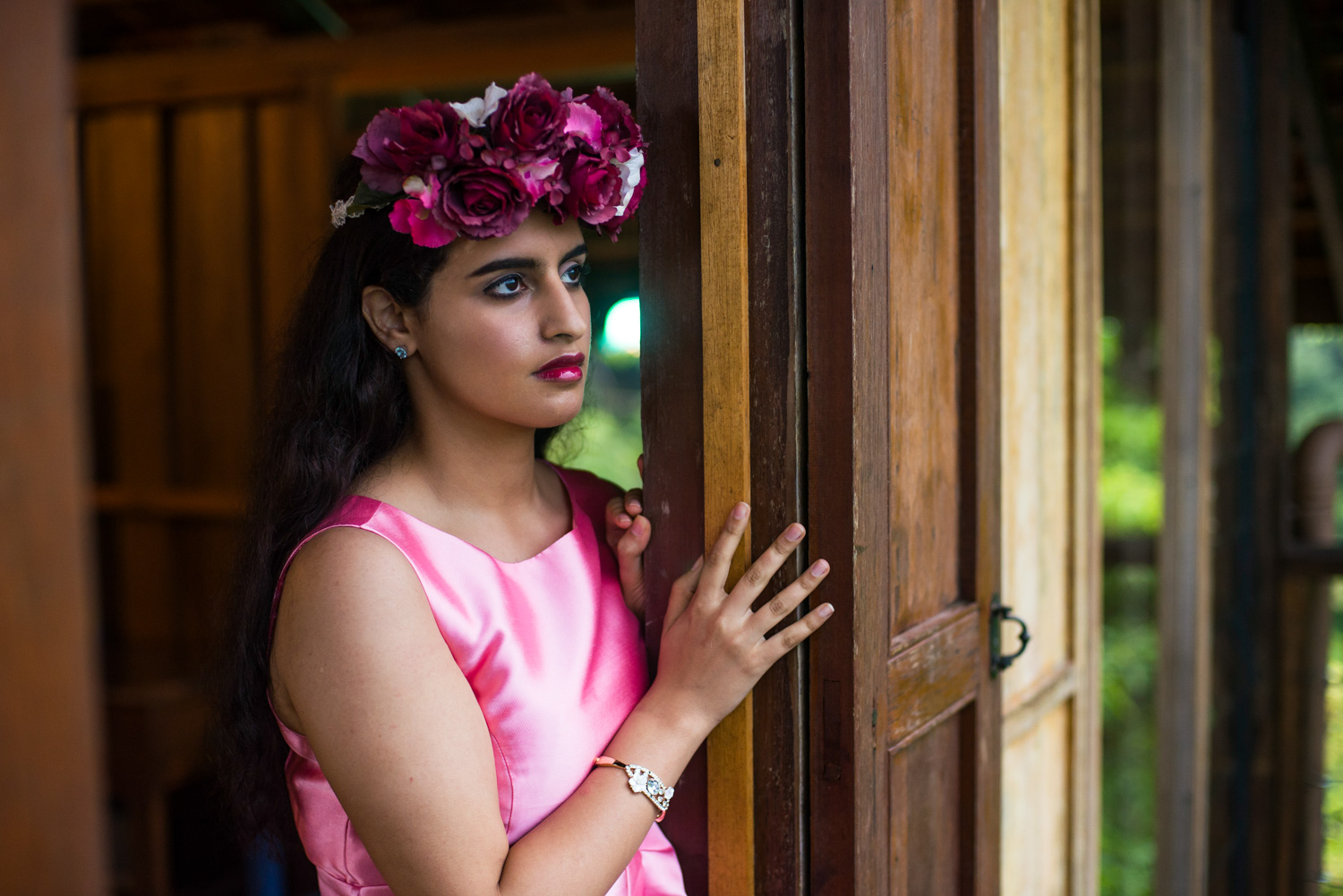 A lady posing, looking out of a Spyder HIll room, during a jungle portraiture session.