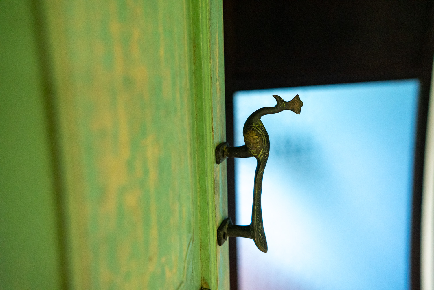Closeup of Spyder Hill artifacts. A door handle featuring a brass peacock.
