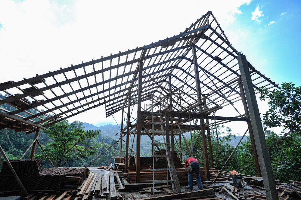 Workers finishing up the Spyder Hill structure and roofing frame during the construction phase.