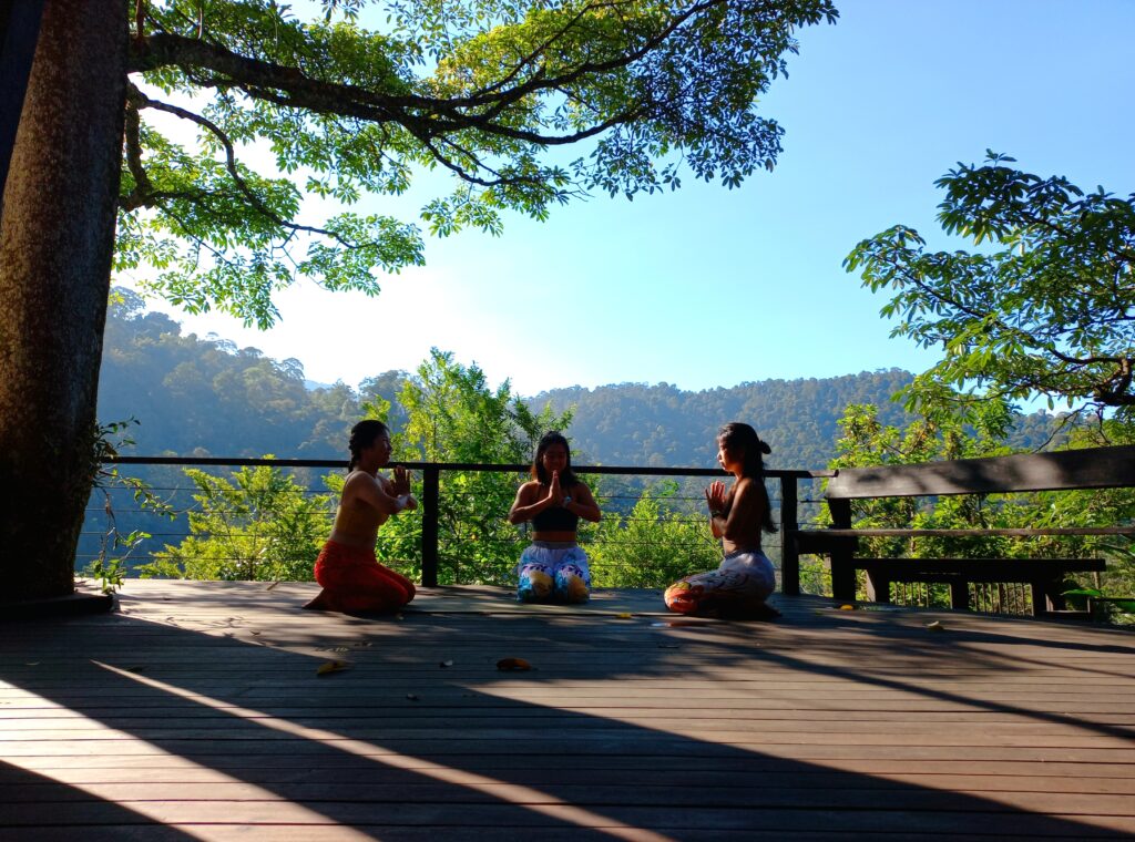 Three yoga practitioners warming on the Spyder Hill deck